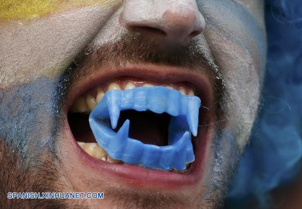Aficionados portan máscara con imagen de Luis Suárez