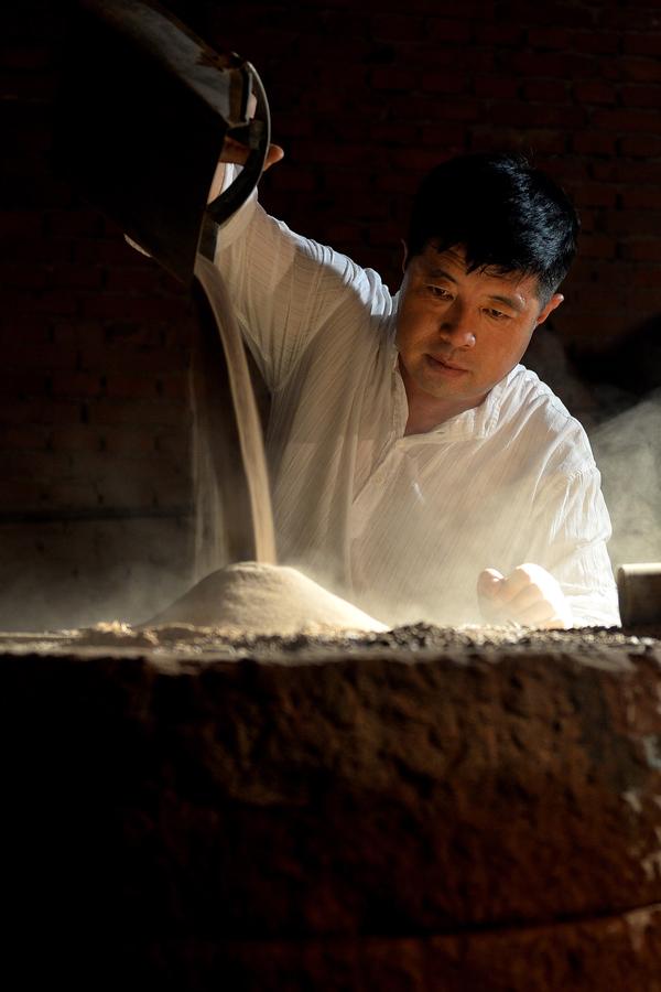 Bai Xuefeng muele y procesa la arena de color morado en su taller en la ciudad de Chaoyang, provincia de Liaoning, 21 de julio.
