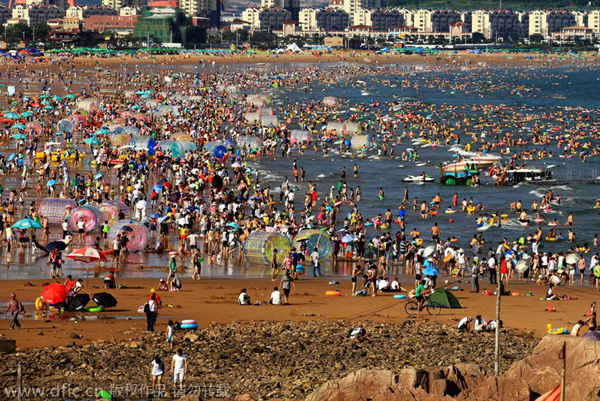 Bañistas se divierten en Golden Beach (Jinshatan) en Qingdao, una ciudad costera de la provincia de Shandong. Cientos de miles de bañistas se refrescan en el mar. 17 de agosto de 2014. [Foto/IC]