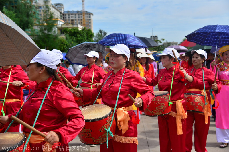 Mujeres Jing tocan tambores tradicionales durante el Festival Ha. 5 de julio de 2014. [Foto/IC]