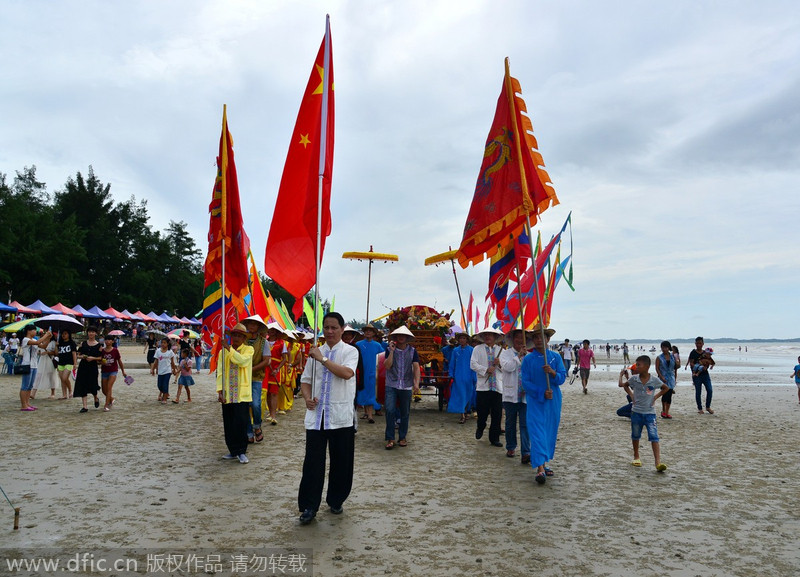 Los Jing, ondeando banderas dan la bienvenida al dios del mar. 5 de julio de 2014. [Foto/IC] 
