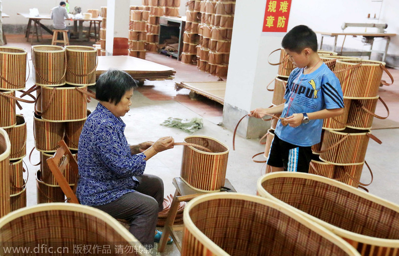 El gobierno -con el objetivo de proteger el medio ambiente- estimula a los agricultores a trabajar en la producción de objetos de bambú y dejar a un lado la tala de árboles. Rongan, Liuzhou, Guangxi Zhuang. 18 de agosto de 2014. [Foto/IC]