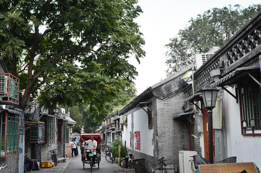 Cao Junlai señala una casa y cuenta historias de los hutones a los turistas en Pekín, el 12 de septiembre de 2014.