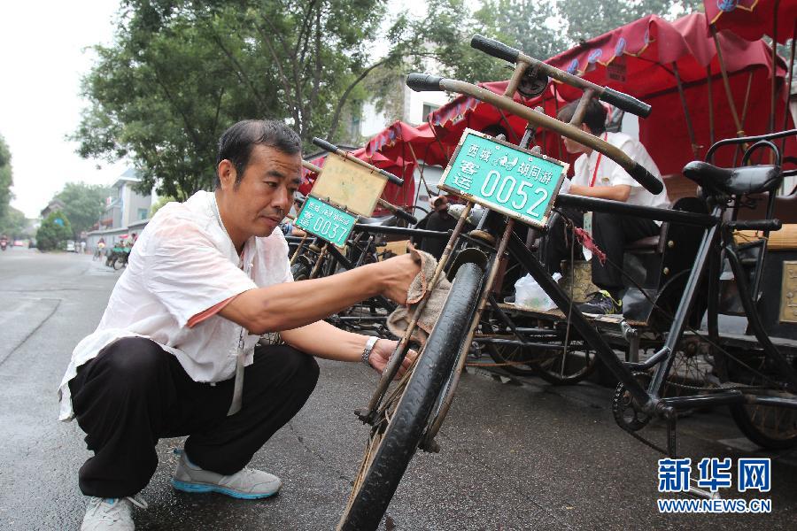 Cao Junlai limpia su rickshaw en Pekín, el 12 de septiembre de 2014. 