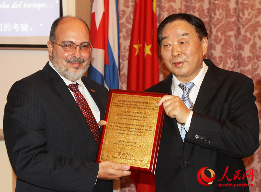 Qiao Xiaoyang, presidente de la comisión de asuntos legislativos de la Asamblea Popular Nacional de China, entrega un reconocimiento a la Universidad de La Habana. (Foto: Yasef Ananda)