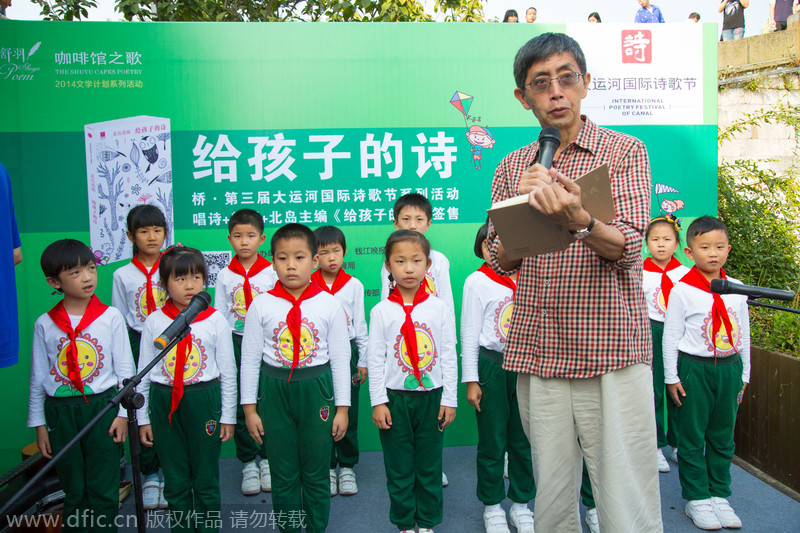 Bei Dao recita un poema junto a algunos estudiantes de primaria. [Foto/IC]