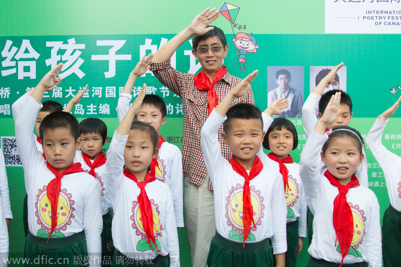 Bei Dao saluda junto a con los estudiantes de primaria. [Foto/IC]