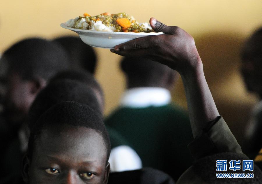 16 de octubre 2012, en la escuela secundaria de Nairobi, capital de Kenia, los estudiantes en el comedor recogen su comida en filas. (Foto: Haitao Ding/ Xinhua)