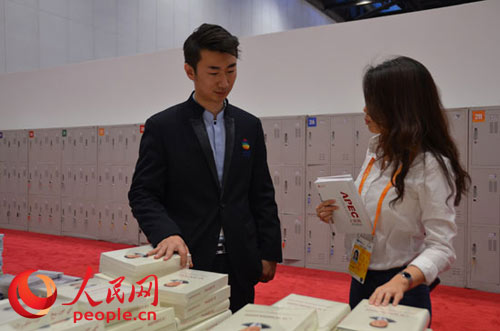 Liu Xiaofei, funcionario del grupo de difusión de la Oficina de Preparativos de APEC Beijing, presentó el libro al periodista. (Foto: Li Tong del Pueblo en Línea)
