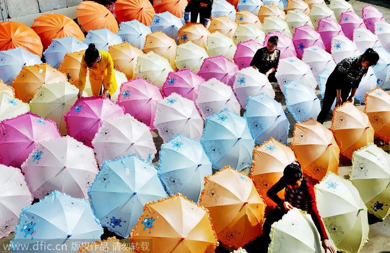 Las trabajadoras secan los paraguas en un pueblo de la ciudad de Dexing, en la provincia de Jiangxi, el 29 de noviembre de 2014. [Foto/IC]