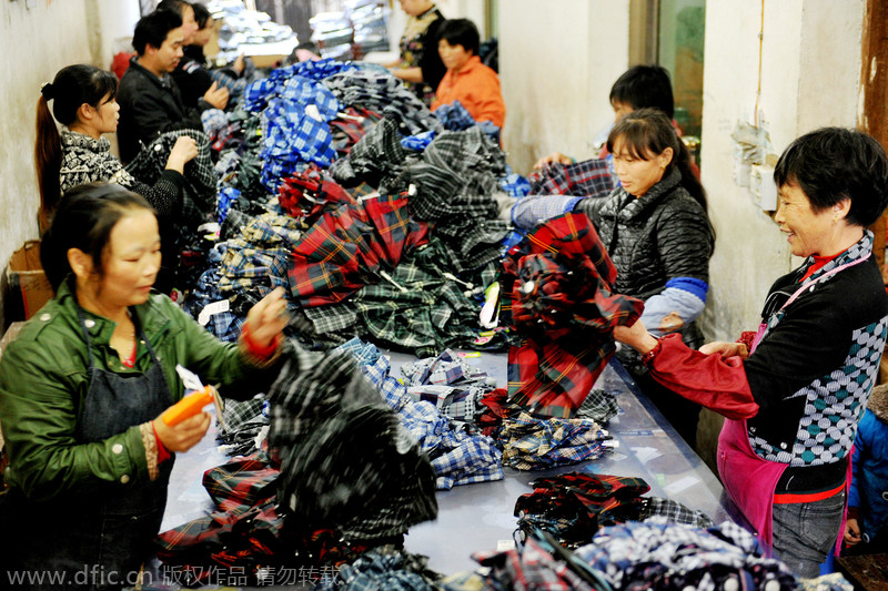 Las trabajadoras unen las partes del interior del paraguas antes de exportarlo al sudeste asiático en un pueblo de la ciudad de Dexing, en la provincia de Jiangxi, el 29 de noviembre de 2014. [Foto/IC]