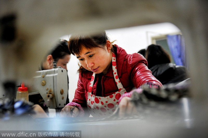 Una trabajadora cose un paraguas en un pueblo de la ciudad de Dexing, en la provincia de Jiangxi, el 29 de noviembre de 2014. [Foto/IC]