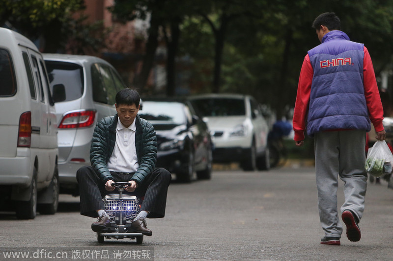 Transeúnte observa a Xu conduciendo su mini coche por las calles de Shanghai, el 2 de diciembre de 2014. [Foto/IC]