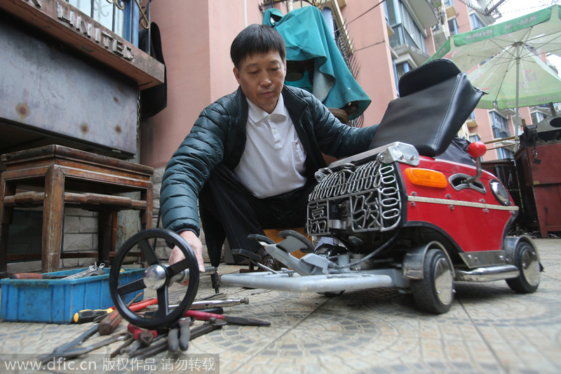 Xu revisa su mini coche en su casa de Shanghai. [Foto/IC]