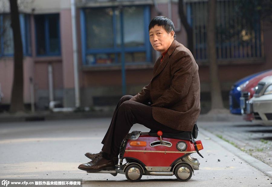 Xu Zhiyun conduce su mini coche fabricado a sí mismo en Shanghai, el 24 de diciembre de 2014. [Foto/CFP]
