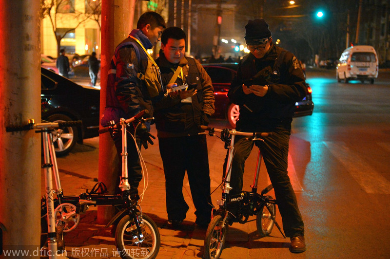 Li Xiaodong y otros conductores privados esperan la llamada de clientes, en Shijiazhuang, provincia de Hebei, el 17 de diciembre de 2014. [Foto/IC]