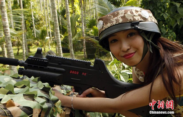 Las candidatas "Miss Leisure 2014", camuflajeadas y sosteniendo armas láser, juegan al Counter-Strike en Hainan. [Foto: Chinanews.com]