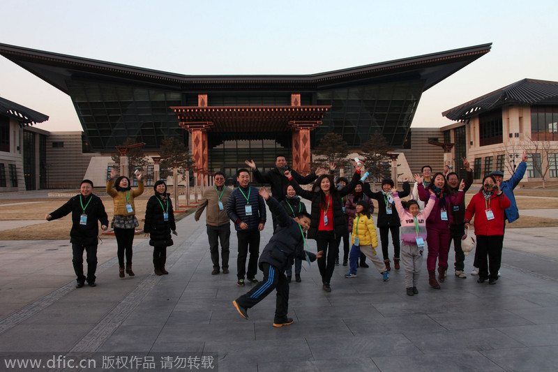 Varios turistas se hacen una foto fuera del centro de convenciones del lago Yanqi, el 1 de enero de 2015. [Foto/IC]