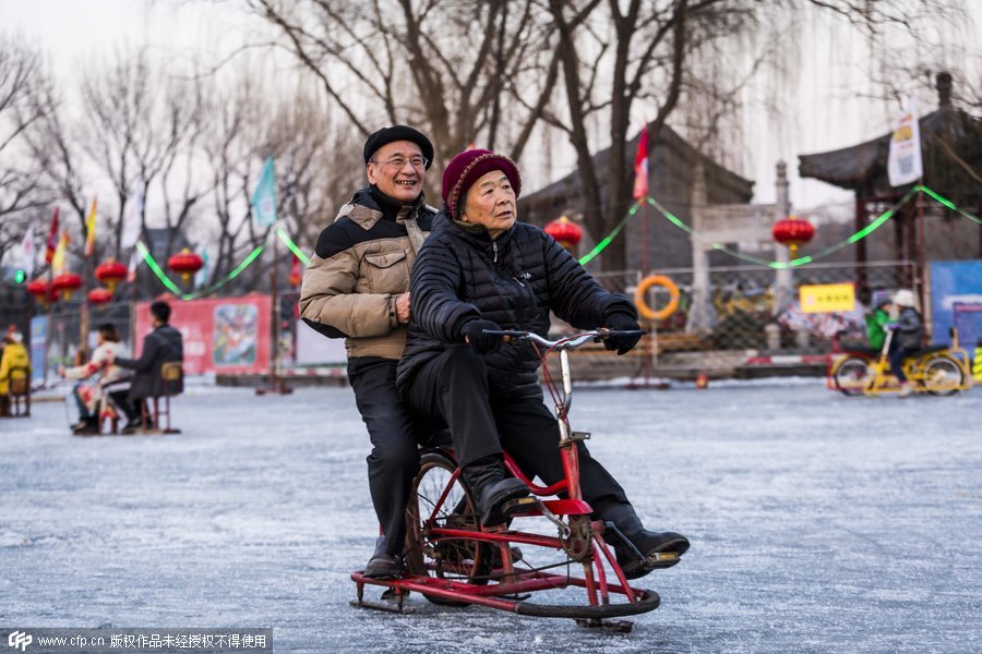 Una pareja de ancianos se divierte conduciendo una bici-trineo. [Foto/CFP]