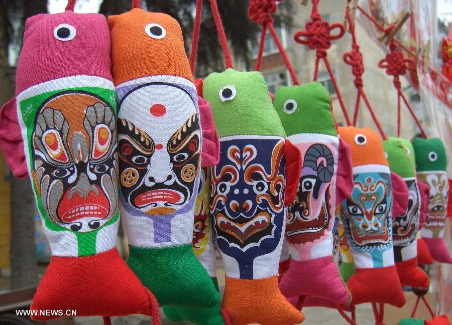Almohadas con forma de pez son decoradas con las máscara la Ópera de Pekín en Zaozhuang, provincia de Shandong. En China, las máscaras de la Ópera de Pekín se han ido convirtiendo en una nueva moda. (Foto: Fan Jiashan) (Xinhua)