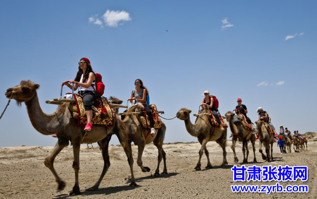 Los estudiantes alemanes pasean en camellos por el desierto en la ciudad de Zhangye, provincia de Gansu, el 14 de junio de 2015. 