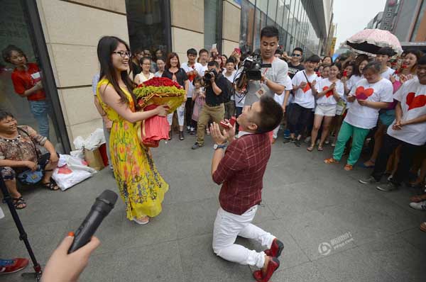 Zhang se arrodilla para pedirle matrimonio a su novia en la calle Chunxi de Chengdu, provincia de Sichuan, el 28 de junio de 2015.