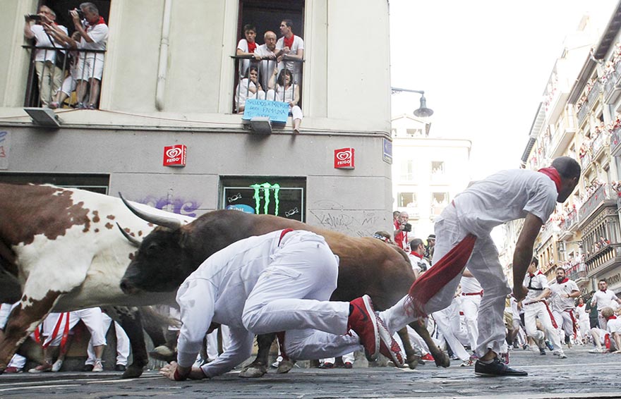 Un corredor se cae cerca de un toro de Jandilla en la peligrosa curva de los Mercaderes durante el inicio de la fiesta de San Fermín en Pamplona, España, el 7 de julio de 2015. Dos corredores fueron investidos por los toros a los 2 minutos y 23 segundos según la prensa local. [Agencias de fotografía]