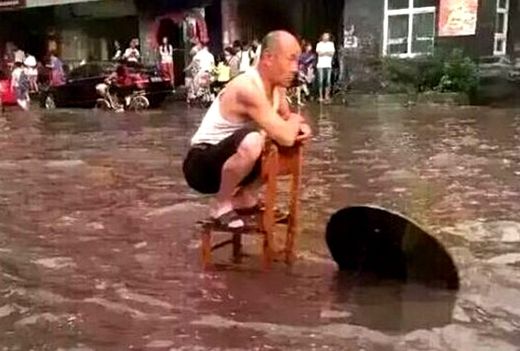 El "mejor abuelo " en cuclillas sobre una silla durante la inundación