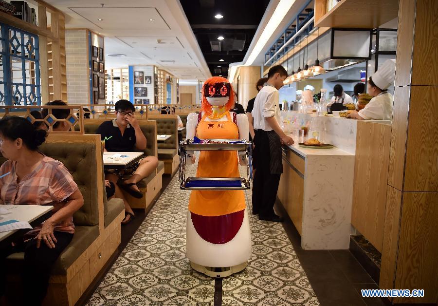 La camarera robot entrega los platos a los clientes en Haikou, capital de la provincia de Hainan, el 3 de agosto de 2015. La camarerao robot trabaja en un restaurante de Haikou. [Foto/Xinhua]