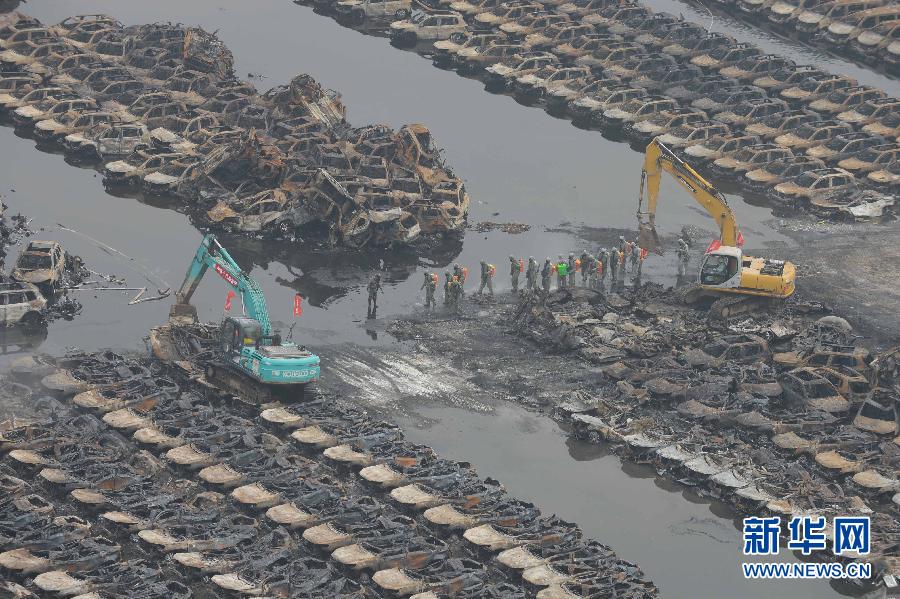 El servicio de rescate y varias máquinas retiran los vehículos calcinados tras la explosión de Tianjin, el 20 de agosto. [Foto/Xinhua]