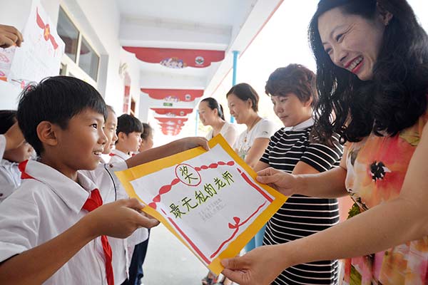 Los estudiantes dan a sus maestros certificados de méritos para expresar su agradecimiento el jueves, día de los profesores, en una escuela primaria de Handan, provincia de Hebei. HAO QUNYING /CHINA DAILY