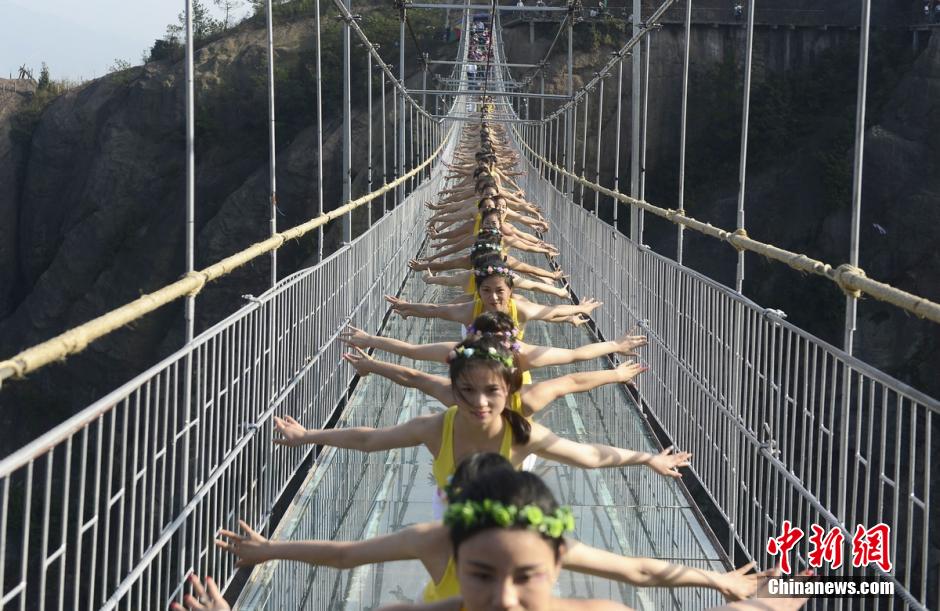 100 hermosas jóvenes practican Yoga en un puente de cristal