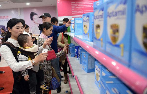 Una mamá china compra pañales con su bebé a cuestas en un supermercado de Guangzhou, provincia de Guangdong, el 23 de enero. 