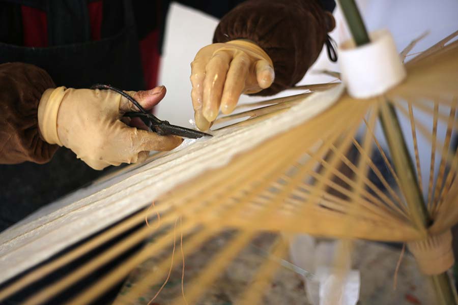 Una mujer fabrica una sombrilla de papel de Yuhang en la aldea de Tangbu, distrito de Yuhang en Hangzhou, provincia de Zhejiang.