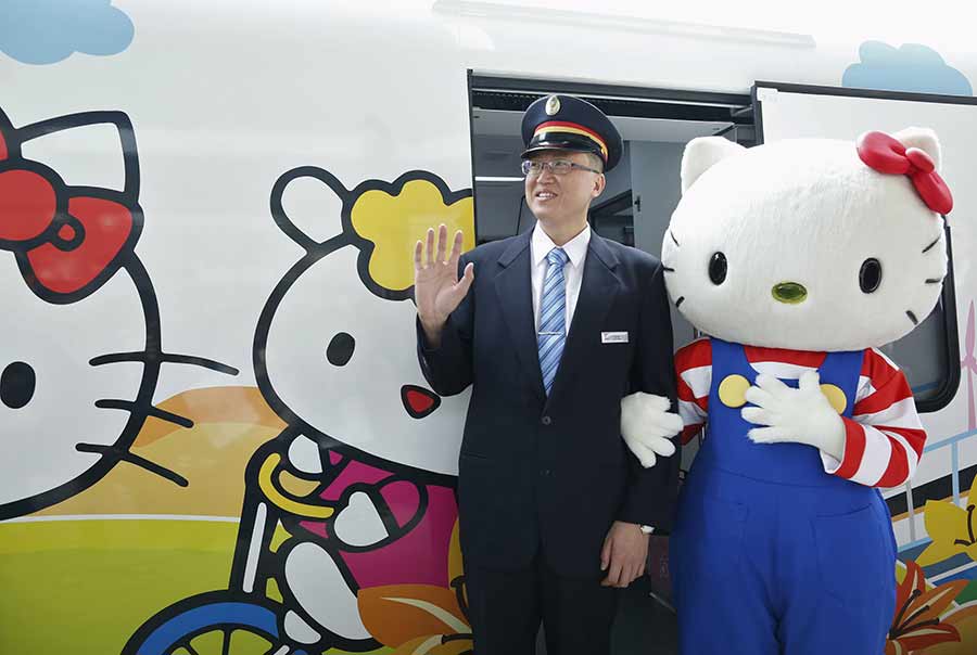 Un empleado disfrazado de Hello Kitty se hace una foto junto al conductor del tren Taroko Express con temática de Hello Kitty en Taipei, el 21 de marzo de 2016. [Foto/Agencias]