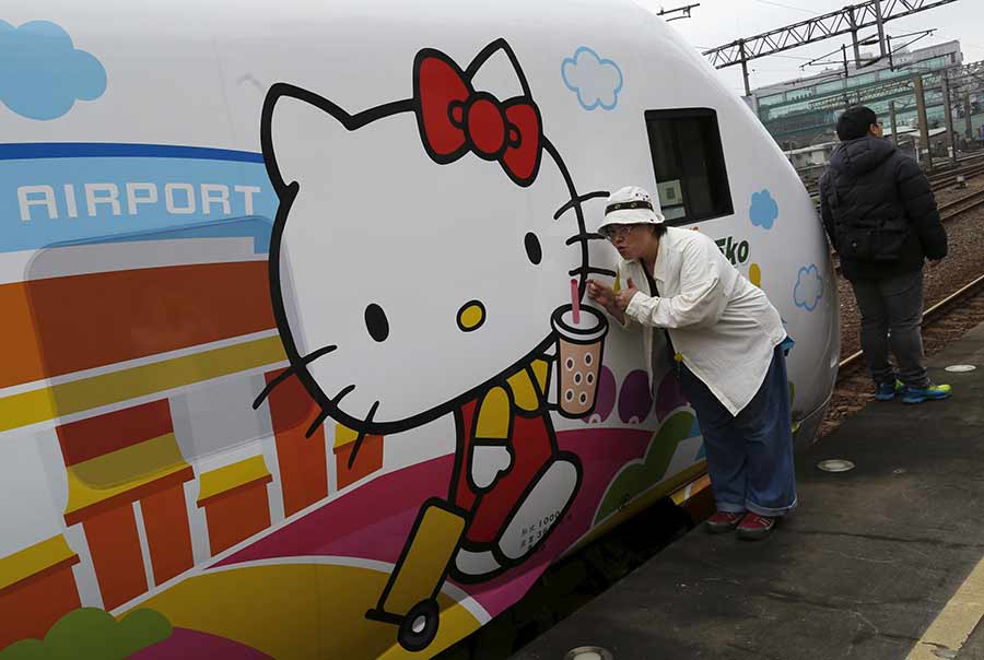 Una fan se hace fotos junto al tren Taroko Express con temática de Hello Kitty en Taipei, el 21 de marzo de 2016. [Foto/Agencias]