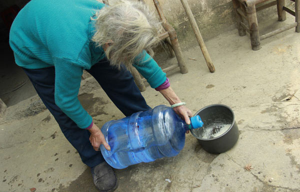Una mujer cocina arroz con agua mineral embotellada en esta foto de archivo. 