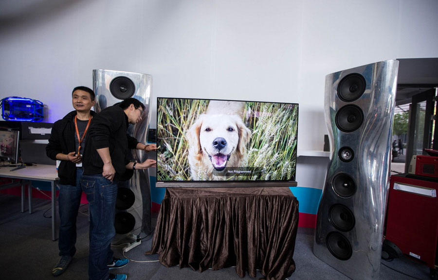 Un hombre toca una pantalla de televisión en exhibición en la Cumbre Ecológica de Tmall en Hangzhou, el 11 de abril de 2016.