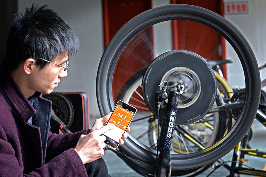 Sun Huangmin controla la velocidad de la rueda a través del smartphone en su estudio en la ciudad de Nanchang, provincia de Jiangxi. El 17 de abril de 2016. [Foto/Xinhua]
