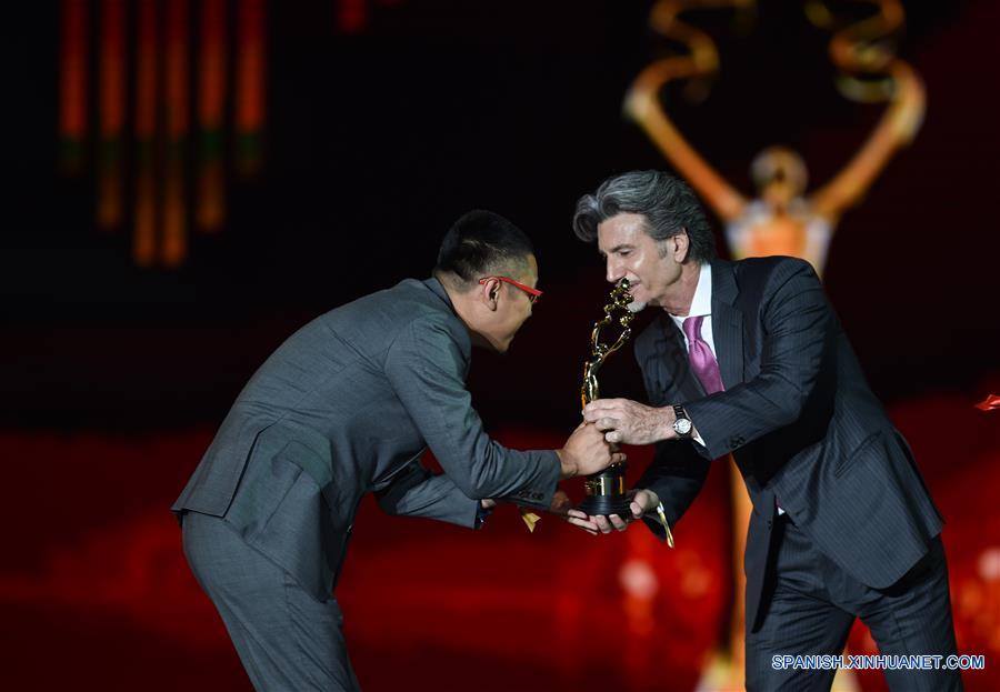Director Anthony LaMolinara(R) presents the trophy of the Tiantan Award for Best Visual Effects to director Han Yan for movie "Go Away! Mr. Tumor" at closing ceremony of the 6th Beijing International Film Festival (BJIFF) in Beijing, capital of China, April 23, 2016. (Xinhua/Mao Siqian) (zkr)