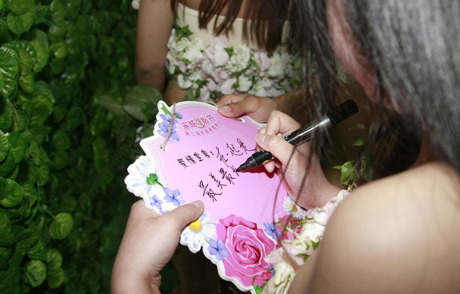 Las parejas escriben sus buenos deseos en la boda en grupo “desnudos” en el área escénica Songcheng de Hangzhou, capital de la provincia de Zhejiang, el 24 de abril de 2016. 