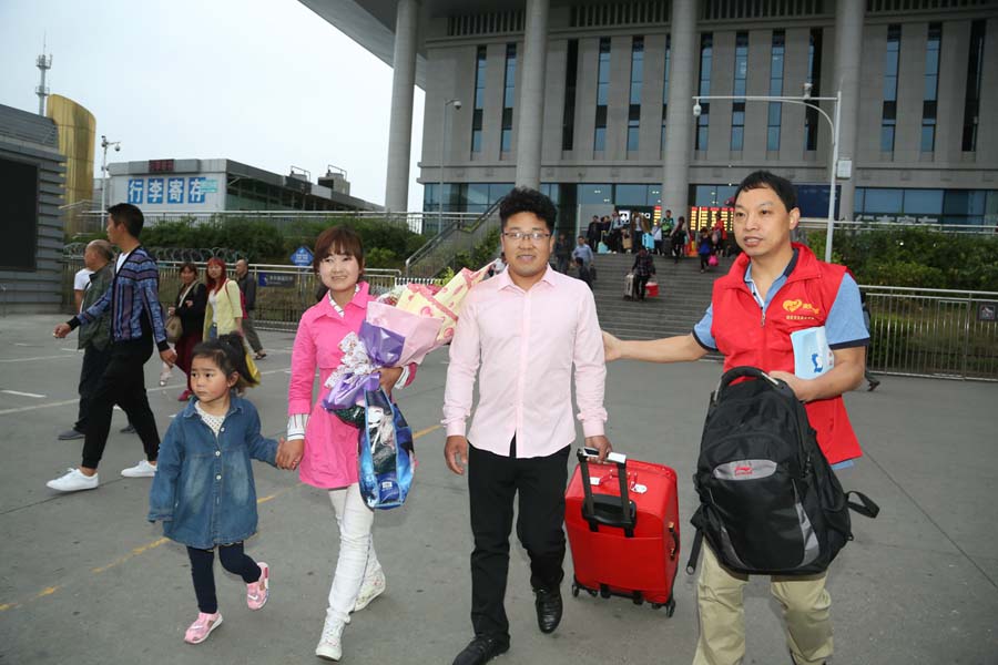Tang Kai llega a la estación de tren de Mianyang, provincia de Sichuan, el 7 de mayo de 2016, en compañía de voluntarios.