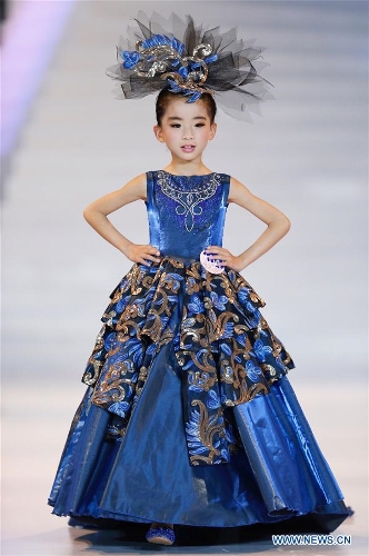 Una participante luce una creación en un concurso de mini-modelos durante la XVI Semana Internacional de la Moda de China en Qingdao, provincia de Shandong, el 14 de mayo de 2016. Más de 200 niños de todo el país participaron en el concurso. (Xinhua/Chen Jianli)