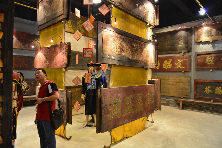 Los visitantes observan la colección de placas en la sala de exposiciones del Museo de Placas de Bayu en Chongqing, el 17 de mayo de 2016. [Foto / Xinhua]