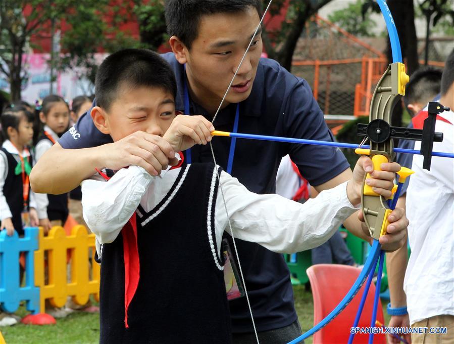 Un niño intenta praticar tiro con arco durante una fiesta de jardín para recibir el próximo Día del Niño, en el Palacio de los Niños del Instituto de Bienestar Infantil (CWI, por sus siglas en inglés) en Shanghai, en el este de China, el 30 de mayo de 2016. (Xinhua/Liu Ying)