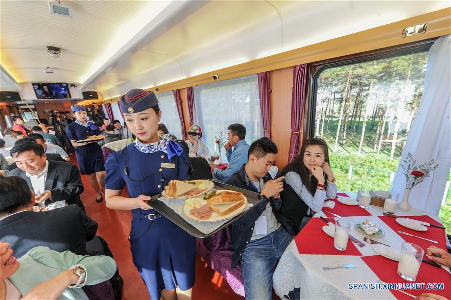 HELONGJIANG, mayo 31, 2016 (Xinhua) -- Pasajeros desayunan en un carro comedor de un tren turístico que corre de Harbin a Heihe, provincia de Helongjiang, en el noroeste de China, el 31 de mayo de 2016. Para satisfacer las necesidades de los turistas, la administración del ferrocarril de Heilongjiang abrió una nueva línea turística de Harbin a Heihe e invitó el martes a algunas personas a experimentar la línea. (Xinhua/Wang Song)