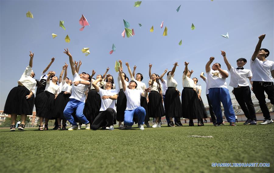 Estudiantes lanzan aviones de papel al aire en la Escuela Experimental en el distrito de Shuangluan de Chengde, provincia de Hebei, en el norte de China, el 2 de junio de 2016.Una variedad de actividades fueron llevadas a cabo para reducir la presión de los estudiantes previo al examen nacional de entrada a la universidad. (Xinhua/Wang Liqun)