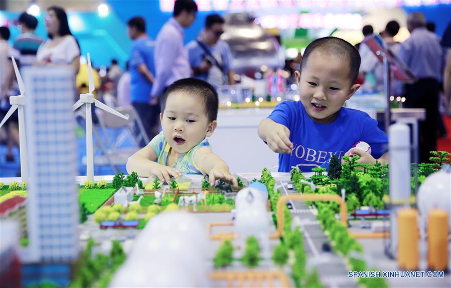 Niños son atraídos por un artículo desplegado durante una exhibición sobre los logros de China en materia de ciencia y tecnología durante el período del XII Plan Quinquenal (2011-2015), en Beijing, capital de China, el 4 de junio de 2016. (Xinhua/Pan Xu)