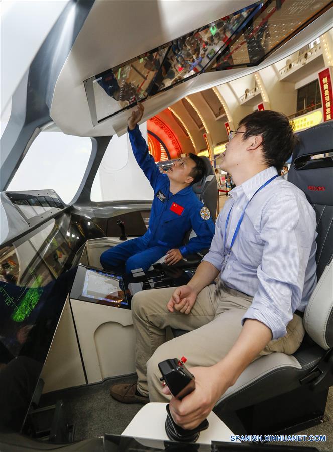 Un ingeniero (i) de pruebas de vuelo conversa con un integrante (d) del equipo de investigación y desarrollo en la cabina inteligente de una aeronave civil de la Corporación de Aviones Comerciales de China, durante una exhibición sobre los logros de China en materia de ciencia y tecnología durante el período del XII Plan Quinquenal (2011-2015), en Beijing, capital de China, el 4 de junio de 2016. (Xinhua/Shen Bohan)