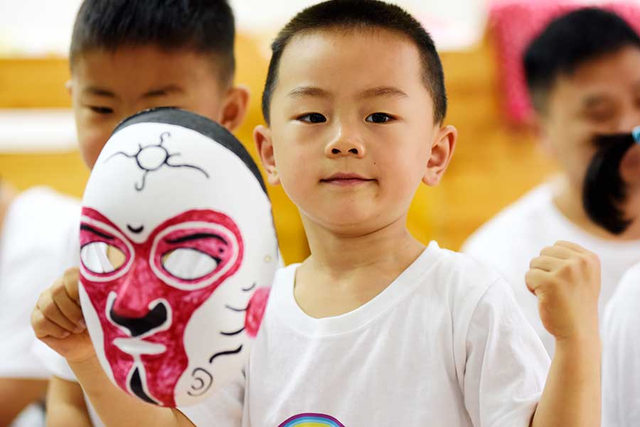 Un niño muestra la máscara facial que hizo de los personajes de la ópera de Pekín en la ciudad de Hefei, provincia de Anhui, el 3 de junio de 2016. [Foto de Ge Yinian/Asianewsphoto]